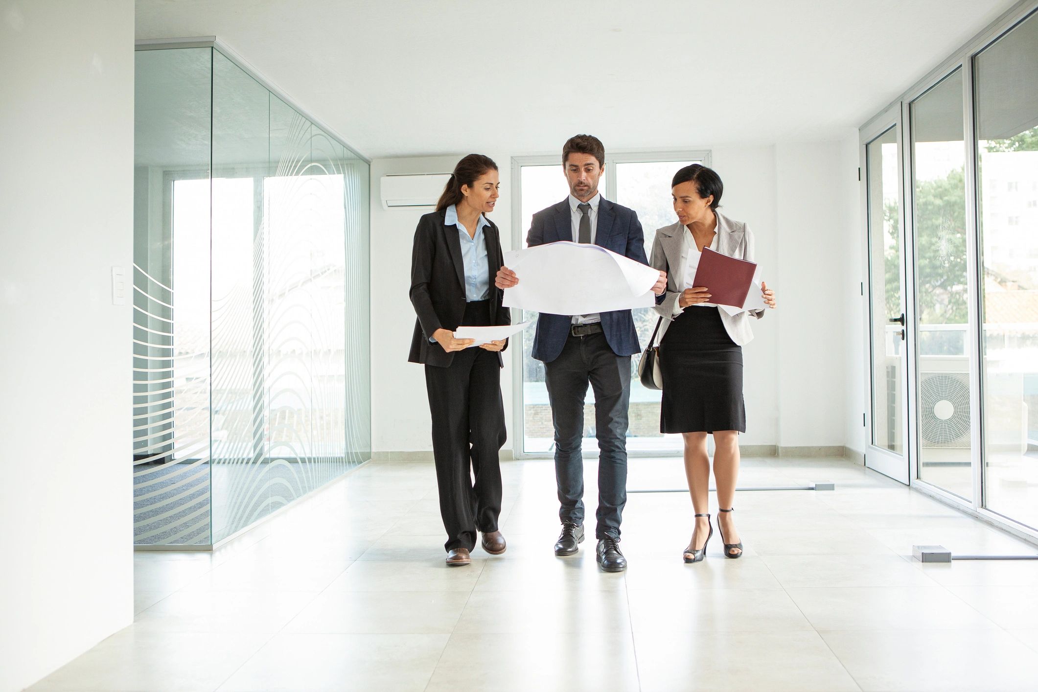 Businesswomen and architect reviewing plans in an office